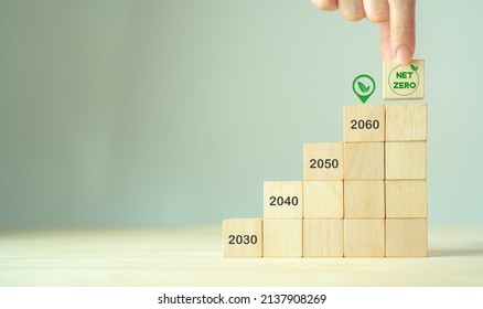 Net Zero By 2060. Carbon Neutral. Sustainalble Development. Successful Execution Of Green Business. Goal Checked In 2060. Go Green Company Culture. Hand Puts Wooden Cube With Net Zero Icon, Copy Space