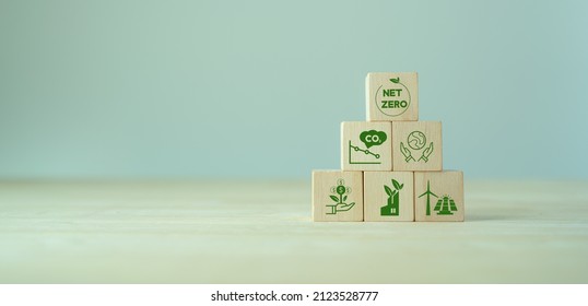 Net zero and carbon neutral concept. Net zero greenhouse gas emissions target. Climate neutral long term strategy. The wooden cubes with green net zero icon and save world icon on grey background. LCA