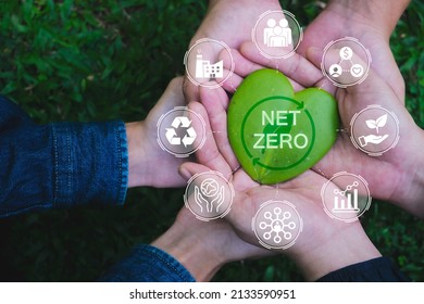 Net zero and carbon neutral concept. Hands adult Teamwork harmony Holding heart leaf on hands with green net zero icon and green icon. Net zero greenhouse gas emissions target. - Shutterstock ID 2133590951