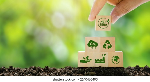 Net Zero and Carbon Neutral Concepts Net Zero Emissions Goals A climate-neutral long-term strategy Ready to put wooden blocks by hand with green net center icon and green icon on gray background. - Shutterstock ID 2140463493