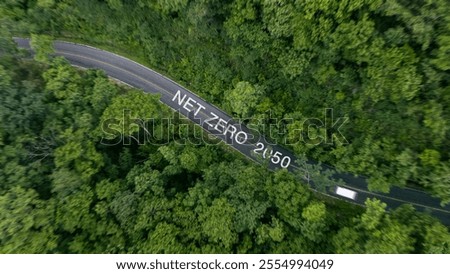 Net zero concept, environmentally friendly goals, net zero greenhouse gas emissions targets and long-term climate neutral strategies. Top view of a street corner amidst a large forest.