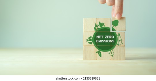 Net zero emissions concept. Carbon neutral. Climate neutral long term strategy. Sustainable business development. Green business. Hand put wooden cubes with net zero emissions icon on grey background. - Shutterstock ID 2135819881