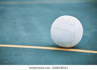 Netball on the ground on a sports court for a match, training or exercise outdoor on a field. Sport, fitness and white ball on the floor for a game, workout or practice competition by a outside arena - Powered by Shutterstock