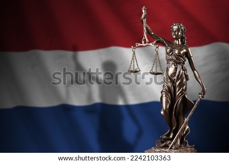 Netherlands flag with statue of lady justice and judicial scales in dark room. Concept of judgement and punishment, background for jury topics