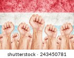 Netherlands Labor movement, workers union strike concept with united male citizens fists raised in the air fighting for their rights, Dutch national flag in out of focus background.