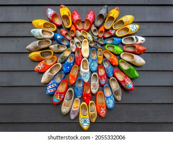 Netherlands. Rough background from gray boards. Many national Dutch Klomp shoes are laid out in the shape of a heart