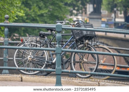 Netherlands. Summer day in Amsterdam. Two bicycles parked near the railing of a bridge over a canal