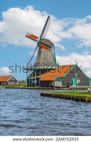 Netherlands. Summer day in Zaanse Schans. Dutch windmill on the bank of the canal