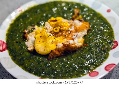 Nettle Cream Soup With Fried Eggs On Top, Homemade.
