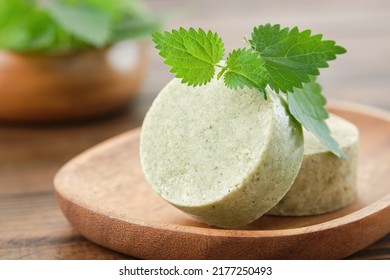 Nettle solid shampoo pieces or homemade natural organic soap bars, fresh green nettle leaves. Selective focus. - Shutterstock ID 2177250493