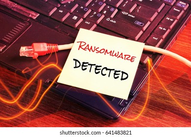 Network cable unplugged from the computer as a RANSOMWARE virus is attacking all computer system. paper written note "RANSOMWARE DETECTED" as a warning 