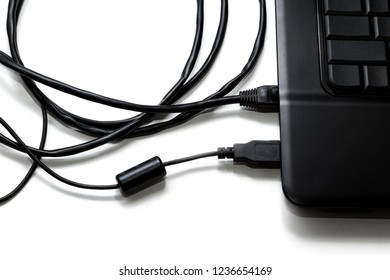 The network cable and USB cable are connected to a black laptop that is located on a white surface. Shallow depth of field.