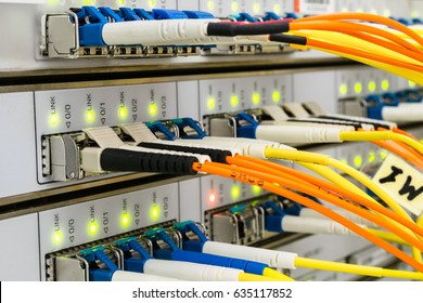  Network cables are connected to the main server. Front panel of the supercomputer located in the server room of the data center. Optical wires are connected to the central router.  Selective focus.