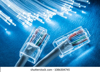 Network cables and optical fibers with lights in the ends at the background.