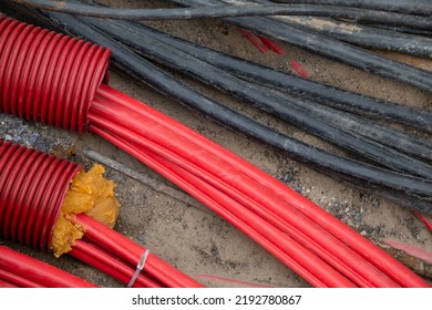 Network cables in red corrugated pipe are buried underground on the street. underground electric cable infrastructure installation. Construction site with A lot of communication Cables
