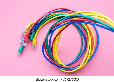 Network colored cables for computer on pink background top view