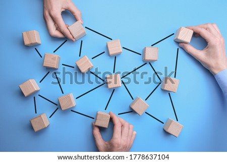 Network Community - man hands put the wooden bricks with person icon on them to blue background which are interconnected. connected people