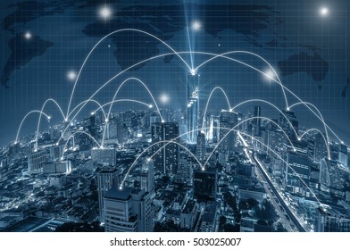 Network connection line between building over the top view of Bangkok Cityscape at night, Mahanakhon and world map background which dicut each elements, cool tone color, network and connection concept