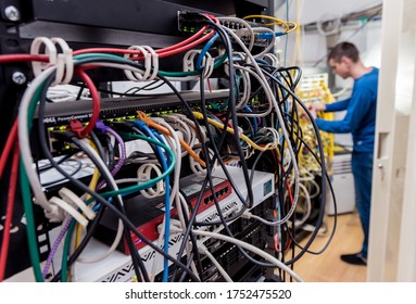 Network engineer working in server room. Connecting network cables to switches