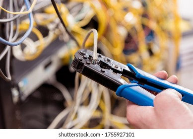 Network engineer working in server room. Connecting network cables to switches
