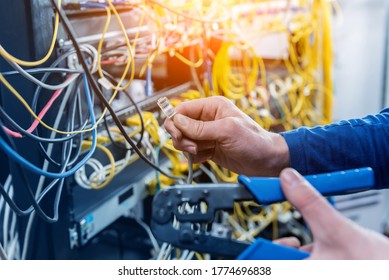 Network engineer working in server room. Connecting network cables to switches