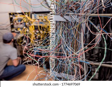 Network engineer working in server room. Connecting network cables to switches