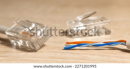 Network Ethernet cable with a connector rj-45 on wood table. Close-up, selective focus. LAN and Connector