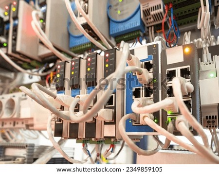 Network hardware. Programmable internet controllers. Network switches. Internet technologies. Network wires are connected to electronic devices. Programmable logic controller. Internet infrastructure