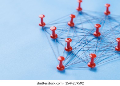 Network With Red Pins And String, An Arrangement Of Colorful Pin