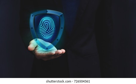 Network Security System Concept, Fingerprint inside a Shield Guard to Protected Identify of User or Personal Information, Present over Businessman Hand, Dark light and Modern Transparent style