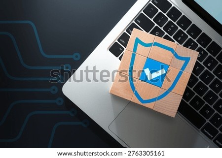 Network security systems and secure data protection technologies. Endpoint encryption. Wooden cubes painted with shield and check mark on laptop keyboard.