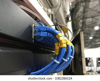 Network switch and Ethernet cables in rack cabinet,UTP cables from a patch panel to computer in factory.
