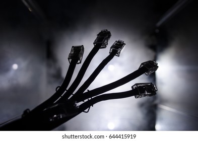 Network switch and ethernet cables, symbol of global communications. Colored network cables on dark background with lights and smoke. Selective focus. Network internet concept background