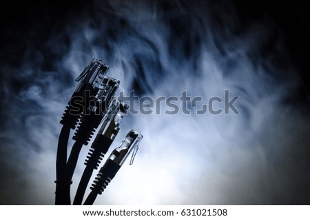 Network switch and ethernet cables, symbol of global communications. Colored network cables on dark background with lights and smoke. Selective focus. Network internet concept background