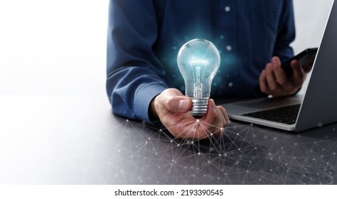 Network Technology And Business Idea Image. Man Holding Lightbulb And Smartphone. Laptop And Computer Network.
