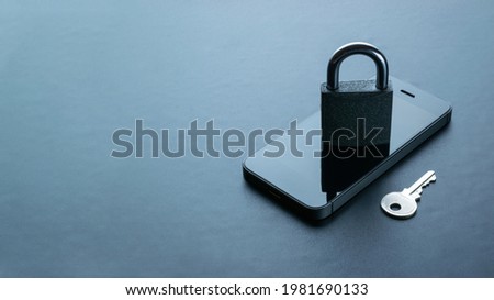Networking security protection. Modern space grey mobile phone with padlock, key on dark background. Smartphone fraud, online scam and cyber security threat