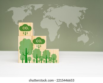 Net-Zero Carbon Emissions by 2050. A Roadmap for the global energy sector. Wooden cubes with CO2 and green tree icons with the world map. Deployment of clean energy innovation. World earth day - Shutterstock ID 2215446653