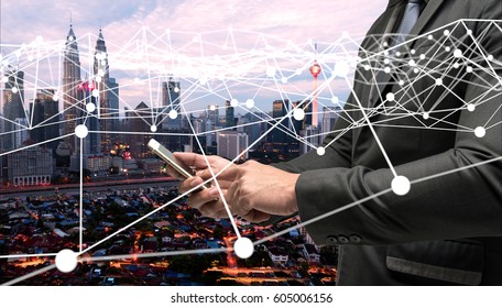 Neural network , digital disruption , smart city and internet of things concept. Business man suit using mobile smart phone technology and atom graphic with city background.