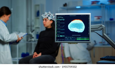 Neurologist doctor analysing nervous system using eeg headset scanning woman brain. Scientist researcher using high tech developing neurological innovation, monitoring side effects on monitor screen