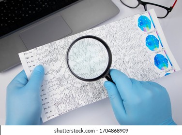 A Neurologist Examines An Encephalogram Of A Patient’s Brain. Schedule Of Electroencephalograms - Study Of Brain Currents For Signs Of Epilepsy And Pathologies Of The Nervous System