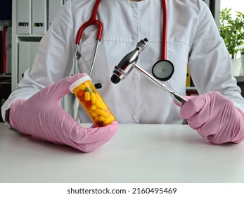 Neurologist holds reflex hammer and pills. Treatment and prevention of various diseases in medicine and neurology antidepressants and sleeping pills