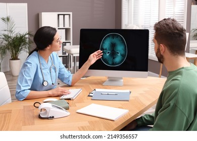 Neurologist Showing Brain Scan To Patient In Clinic