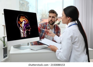 Neurologist Showing Brain Scan To Patient In Clinic