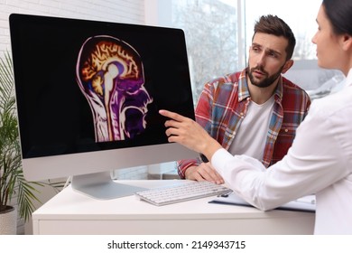 Neurologist Showing Brain Scan To Sad Man In Clinic