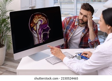 Neurologist Showing Brain Scan To Sad Man In Clinic