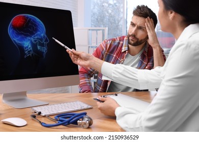 Neurologist Showing Brain Scan To Sad Man In Clinic