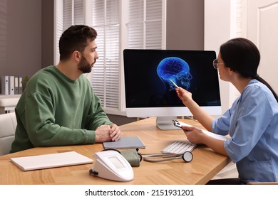 Neurologist Showing Brain Scan To Sad Man In Clinic