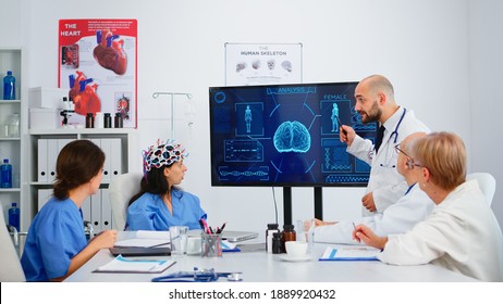 Neurologist Showing New Inovation To Colleagues Discussing Brain Functions Using High Tech In Medical Boardroom. Medic Studying Diagnosis Of Patients Working In Hospital Conference Room