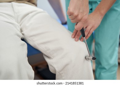 Neurologist using instruments during male patient check-up - Shutterstock ID 2141851381