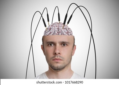 Neuroscience And Brain Research Concept. Young Man Has Cables And Electrodes In His Brain.